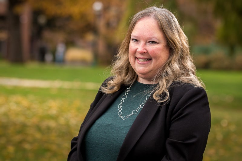 Woman wearing a green blouse under a black sweater