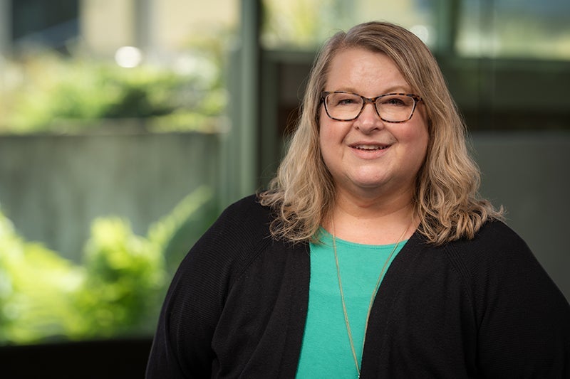 Woman wearing a green shirt under a black sweater