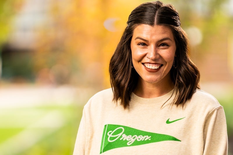 woman with long dark hair wearing an "Oregon" shirt