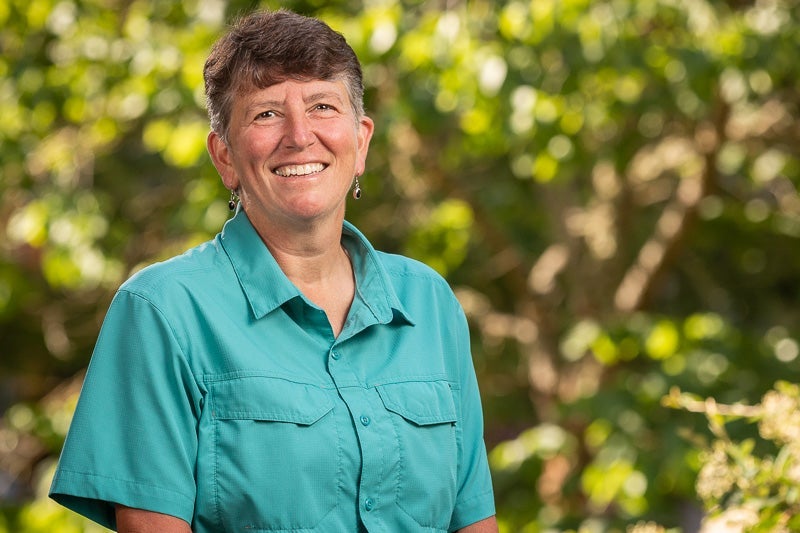 woman with short brown hair wearing a teal shirt