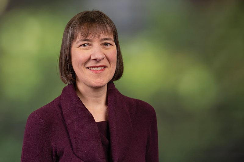 woman with mid-length brown hair wearing a maroon sweater