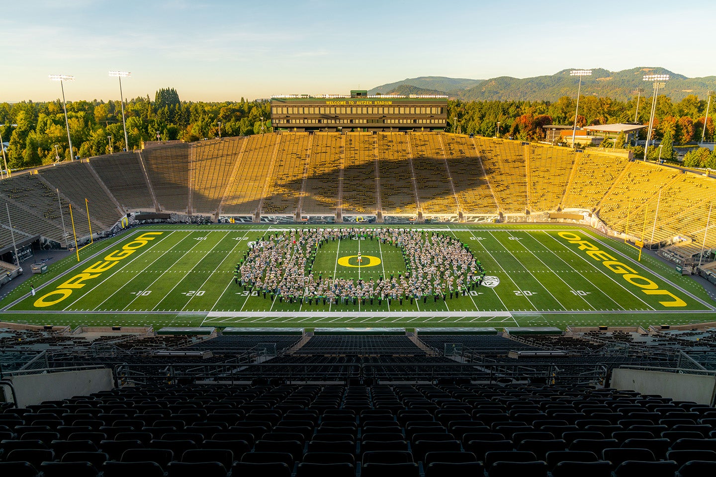 Class of 2024 at Autzen Stadium standing in a pattern of the O logo