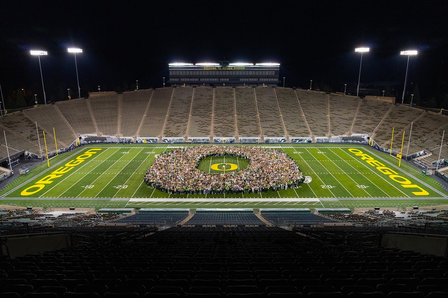 Class of 2024 at Autzen Stadium standing in a pattern of the O logo