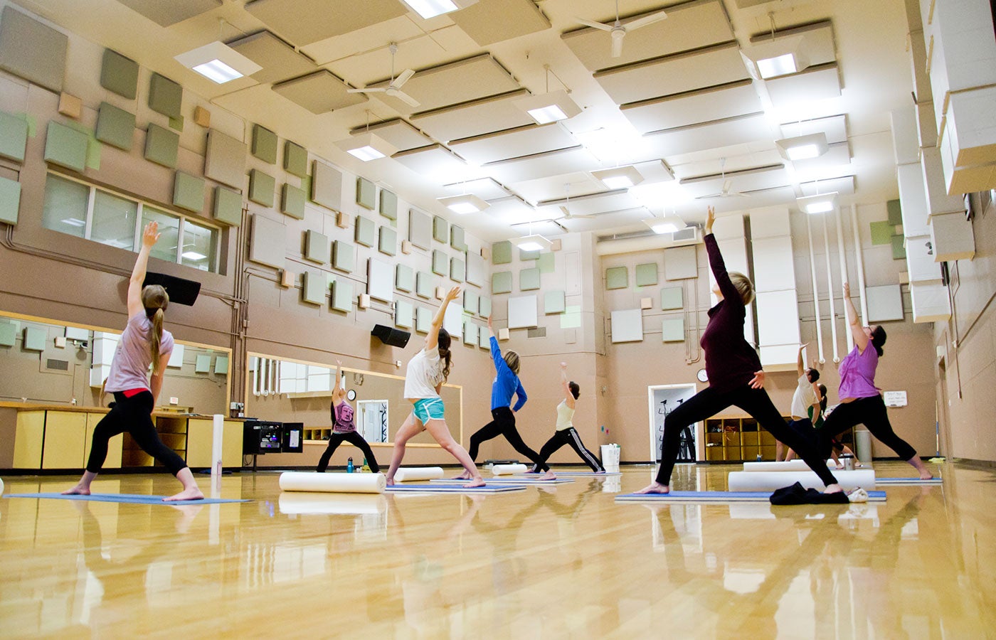 Students doing reverse warrior pose in a yoga class in the Student Recreation Center.